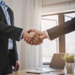 close-up view hands of agent and client shaking hands after signed contract